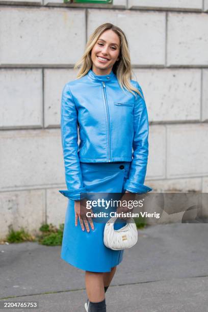 Alix Earle wears blue zipper leather jacket, skirt, white bag outside Miu Miu during the Womenswear Fall/Winter 2025/2026 as part of Paris Fashion...