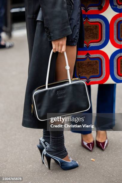 Camila Coelho wears black coat, heels, gauntlets, bag & Aimee Song wears blue pants, coat with print outside Miu Miu during the Womenswear...