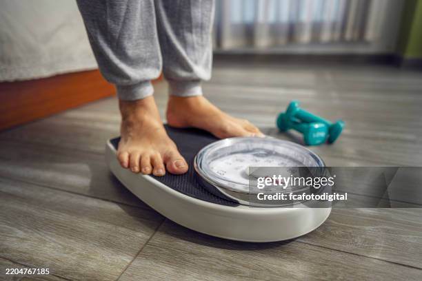 close up of feet standing on weight scale - weight loss stock pictures, royalty-free photos & images