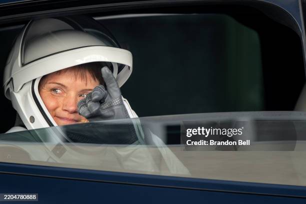 Astronaut commander Anne McClain gestures towards family members, friends and guests while exiting the Neil A. Armstrong Operations and Checkout...