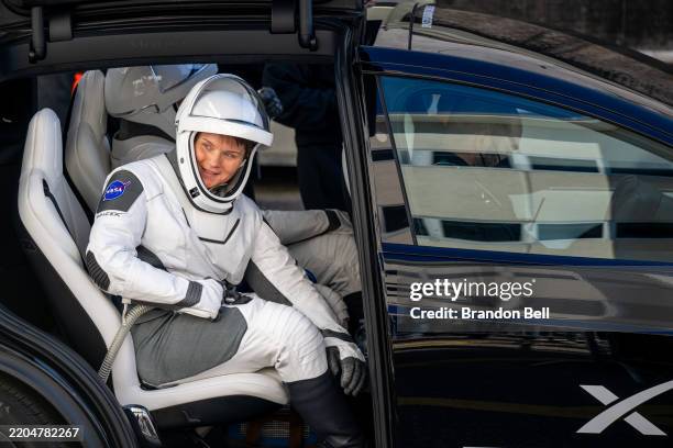 Astronaut commander Anne McClain looks out towards family members, friends and guests while exiting the Neil A. Armstrong Operations and Checkout...
