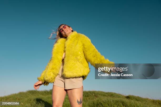 woman dancing outdoor in yellow coat - festivaleiro imagens e fotografias de stock