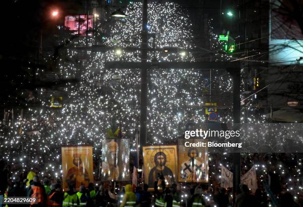 Protesters shine smartphone lights and carry orthodox iconography during an anti-government demonstration in Belgrade, Serbia, on Saturday, March....
