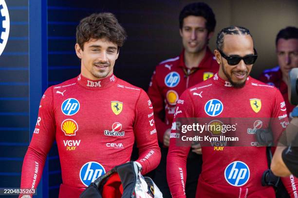 Charles Leclerc of Monaco and Ferrari and Lewis Hamilton of Great Britain and Ferrari walk together in the paddock during previews ahead of the F1...