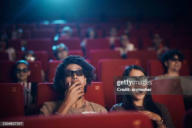 pareja sorprendida disfrutando de una película en 3d en el cine. - cinematografía fotografías e imágenes de stock