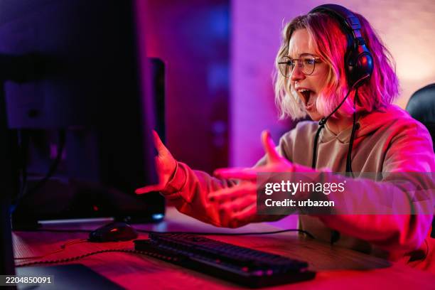 young woman losing while playing a video game on her desktop pc - gamer stock pictures, royalty-free photos & images
