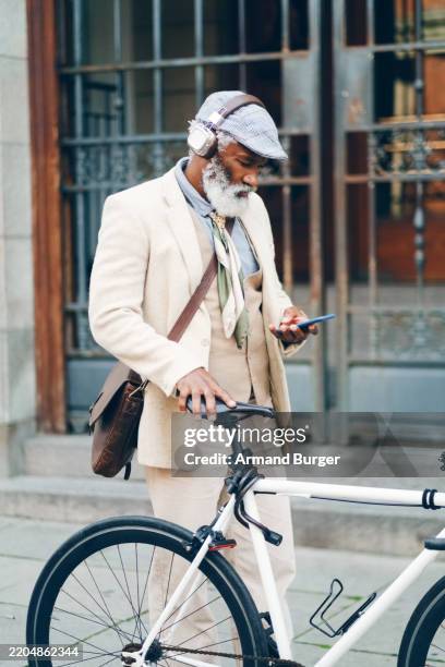 cuffie, viaggio e uomo d'affari con cellulare in bicicletta in città ascoltando musica, radio o playlist al mattino. viaggiare, tecnologia e avvocato maturo con trasporto ecologico in strada in città. - studio legale foto e immagini stock