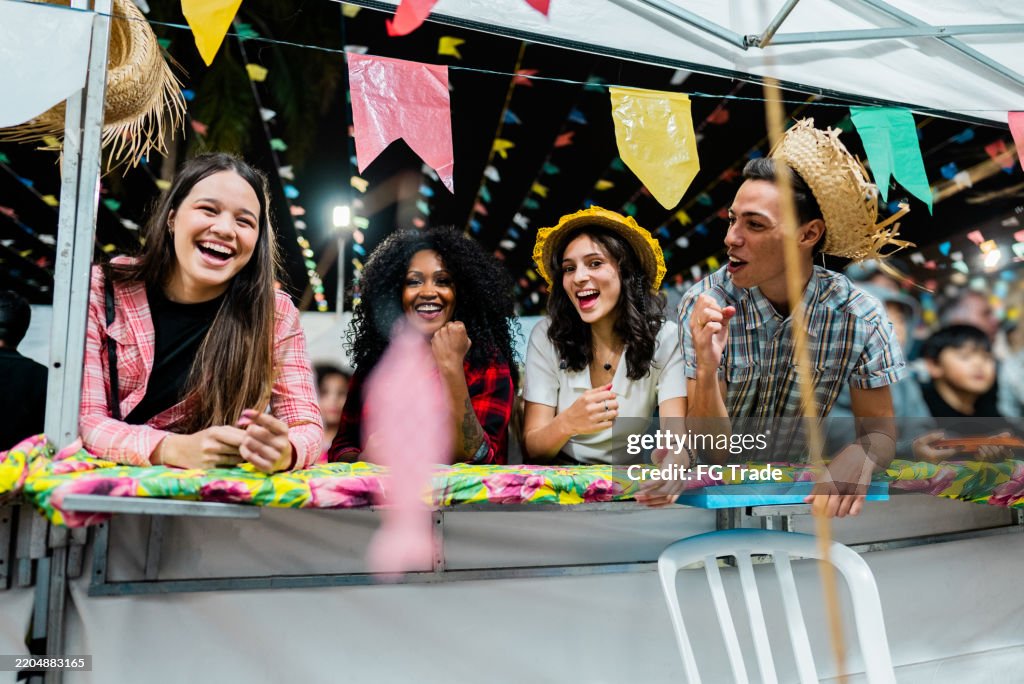 Friends playing fishing game and celebrating at a Brazilian Traditional Festival "Festa Junina"