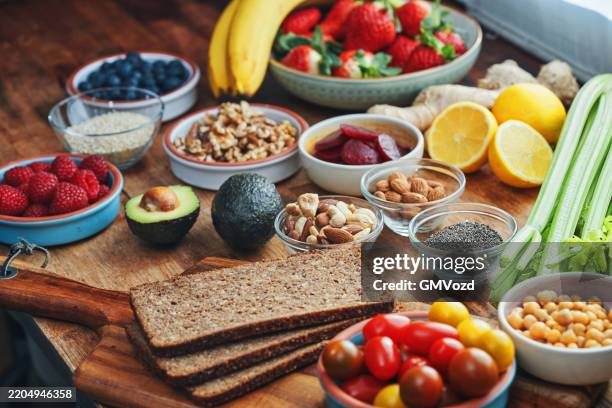 trending foods - superfoods: zubereitung von avocado-toast mit superfood-toppings - vollkorn stock-fotos und bilder