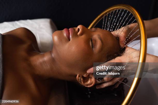 una escena tranquila de una mujer disfrutando de un tratamiento de spa para el cabello. - cuero cabelludo fotografías e imágenes de stock