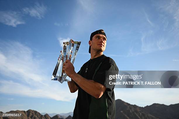 Britain's Jack Draper stands for a portrait with his trophy after winning the men's singles match against Denmark's Holger Rune during the BNP...