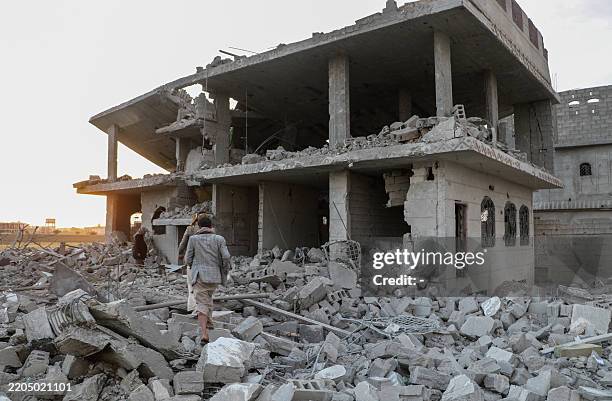 People inspect the rubble of a house hit by a US strike on the weekend in Yemen's northern Saada province on March 17, 2025. Yemen's Huthi rebels...