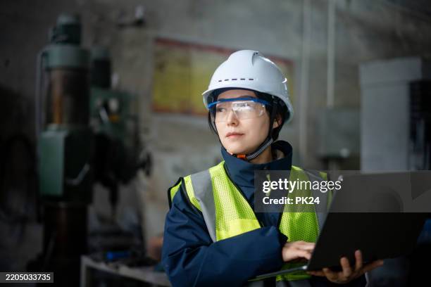 aisan female working on laptop in factory - aisan women stock pictures, royalty-free photos & images