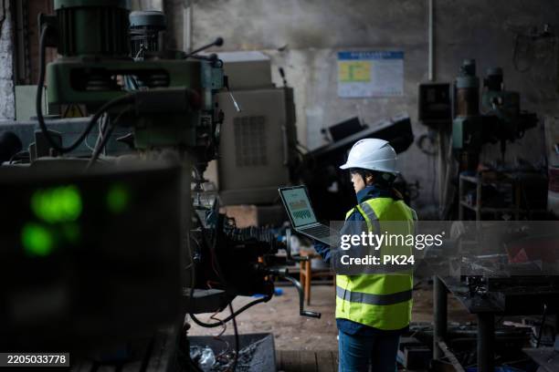 aisan female working on laptop in factory - aisan women stock pictures, royalty-free photos & images