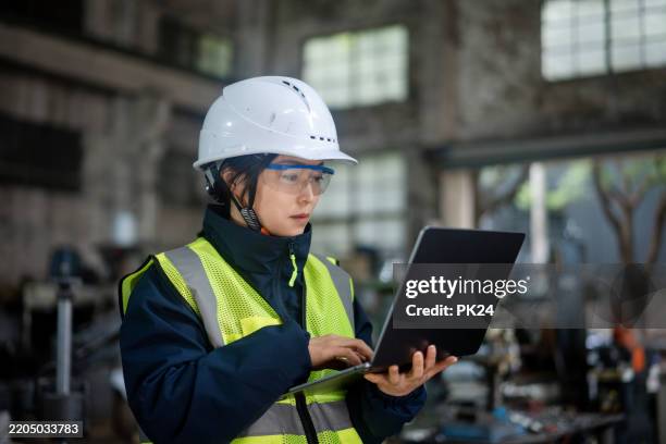 aisan female working on laptop in factory - aisan women stock pictures, royalty-free photos & images
