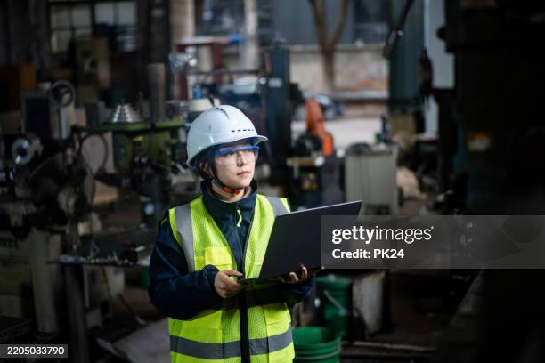 aisan female working on laptop in factory - aisan women stock pictures, royalty-free photos & images