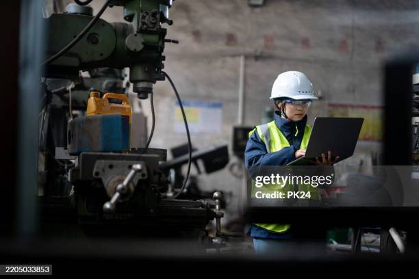 aisan female working on laptop in factory - aisan women stock pictures, royalty-free photos & images