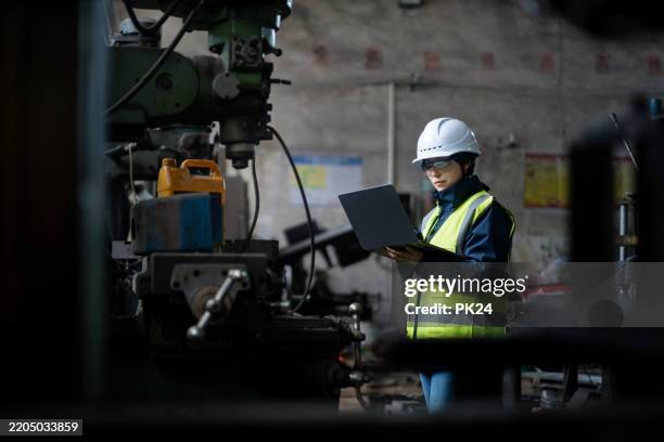 aisan female working on laptop in factory - aisan women stock pictures, royalty-free photos & images