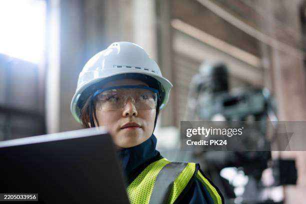 aisan female working on laptop in factory - aisan women stock pictures, royalty-free photos & images