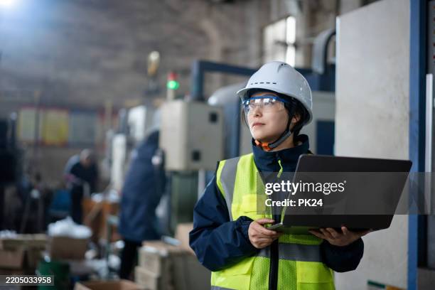 aisan female working on laptop in factory - aisan women stock pictures, royalty-free photos & images