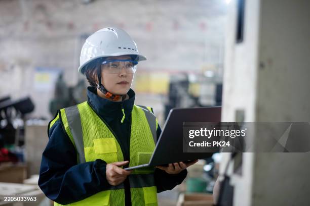 aisan female working on laptop in factory - aisan women stock pictures, royalty-free photos & images