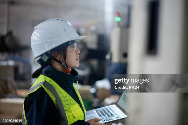 aisan female working on laptop in factory - aisan women stock pictures, royalty-free photos & images