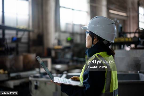aisan female working on laptop in factory - aisan women stock pictures, royalty-free photos & images