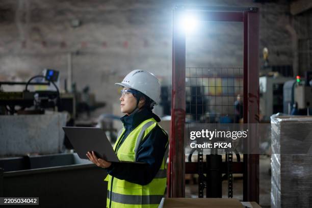 aisan female working on laptop in factory - aisan women stock pictures, royalty-free photos & images