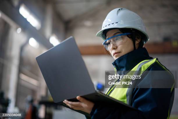 aisan female working on laptop in factory - aisan women stock pictures, royalty-free photos & images
