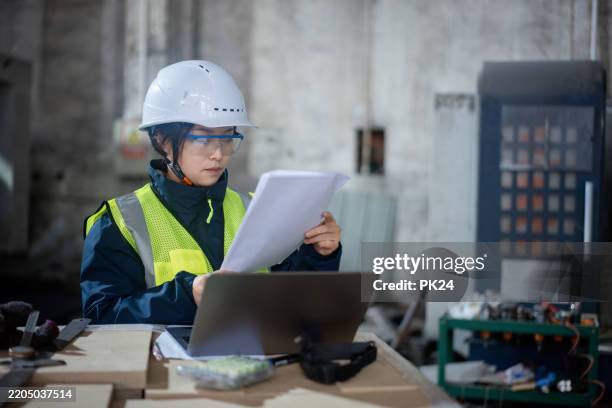 aisan female working on laptop in factory - aisan women stock pictures, royalty-free photos & images
