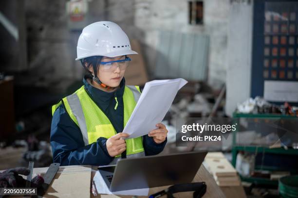 aisan female working on laptop in factory - aisan women stock pictures, royalty-free photos & images
