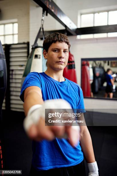 portrait of confident young boxer and wrapped hand - youth club stock pictures, royalty-free photos & images