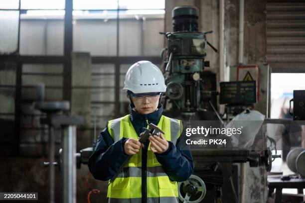 asian female engineers are using vernier caliper in the factory - schieblehre stock-fotos und bilder