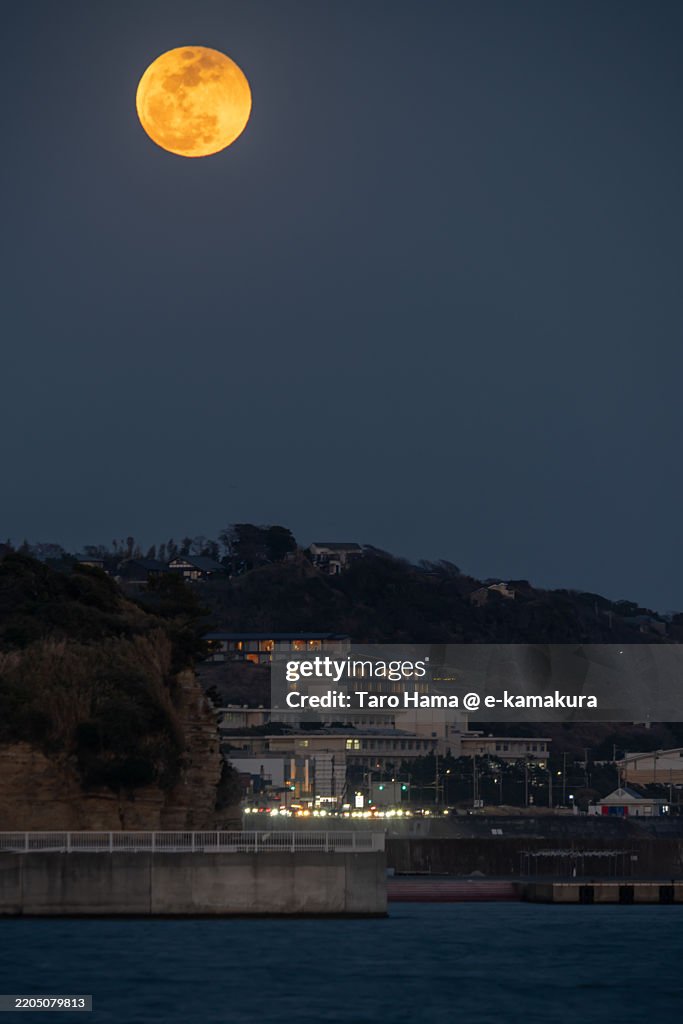 Blood moon over the twilight beach in Kanagawa of Japan
