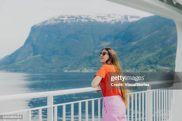 fröhliche frau, die über eine sommerreise nachdenkt, die den fjord mit der fähre überquert - sognefjord stock-fotos und bilder