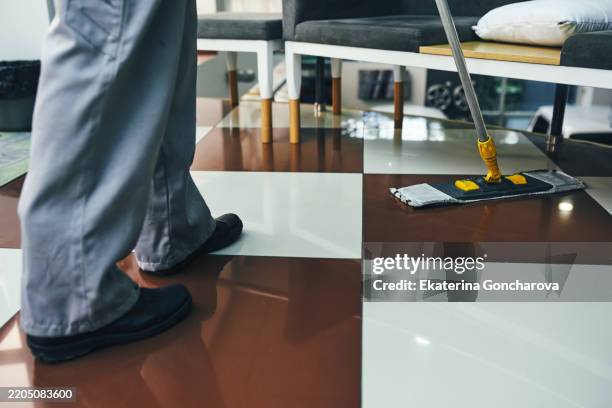professional cleaning service mopping tile floor in modern commercial setting - impresa di pulizie foto e immagini stock