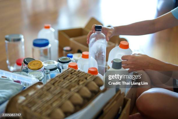woman organizing household recyclables for a sustainable future - circulaire economie stockfoto's en -beelden