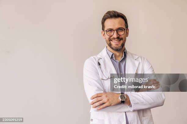 retrato de un médico sonriente con los brazos cruzados y el estetoscopio - doctora fotografías e imágenes de stock