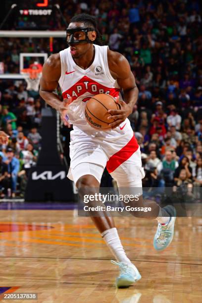 Jonathan Mogbo of the Toronto Raptors dribbles the ball during the game against the Phoenix Suns on March 17, 2025 at Footprint Center in Phoenix,...