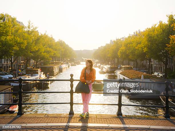 mujer disfrutando del clima soleado en amsterdam, países bajos - amsterdam fotografías e imágenes de stock