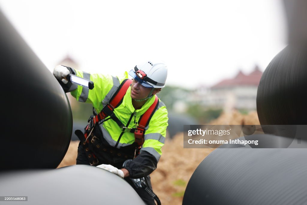 Flashlight Using Contuction Worker Construction Worker At The Cylindrical Tunnel Inspecting It With A ...