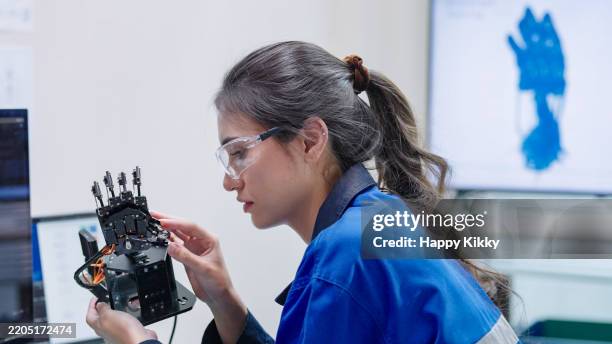 close up engineer developer in robotics arm prototype demonstrating a practical robotics in human-machine interaction controller and checking robotic parts hardware and applied software - maquinaria de fabrico imagens e fotografias de stock