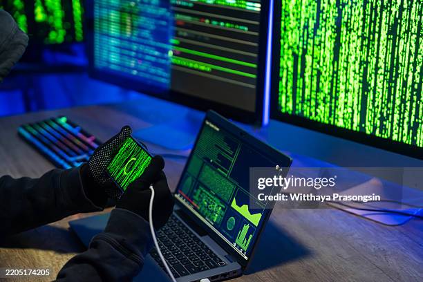 hacker using technology to access secure systems in a dark room - computer malware stock pictures, royalty-free photos & images