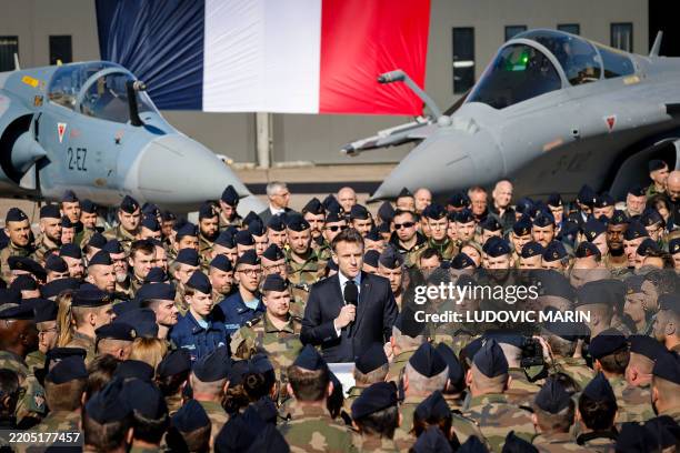 France's President Emmanuel Macron delivers a speech in front of a Dassault Mirage 2000 and a Dassault Rafale fighter aircrafts during his visit of...