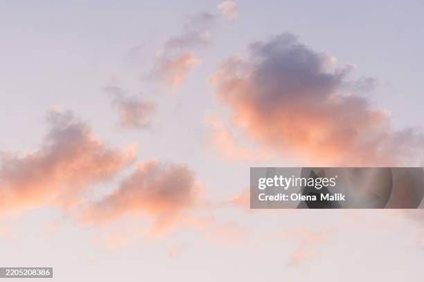 vibrant sunset sky with soft pink and orange cloud formations - vervagen stockfoto's en -beelden