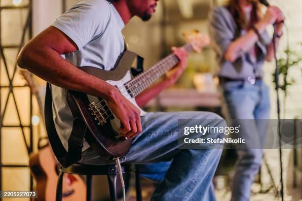 talentierter bassgitarrist, der sein instrument spielt - bass gitarre stock-fotos und bilder