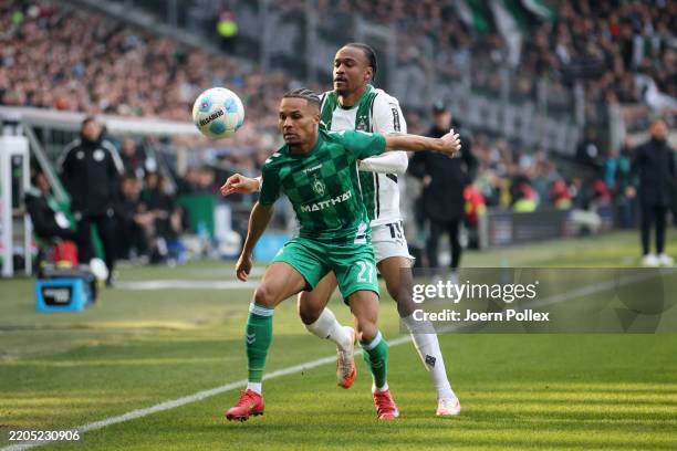 Felix Agu of Werder Bremen is challenged by Nathan Ngoumou of Borussia Moenchengladbach during the Bundesliga match between SV Werder Bremen and...