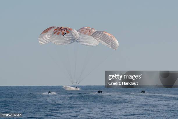 In this handout image provided by NASA, A SpaceX Dragon spacecraft is seen as it lands with NASA astronauts Nick Hague, Suni Williams, Butch Wilmore,...