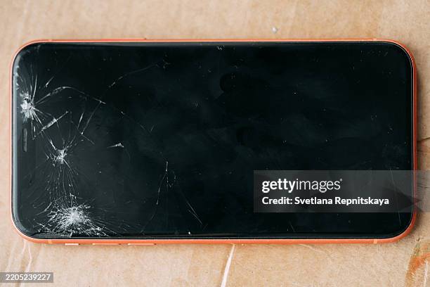 broken smartphone screen laying on cardboard surface - screen replacement stock pictures, royalty-free photos & images