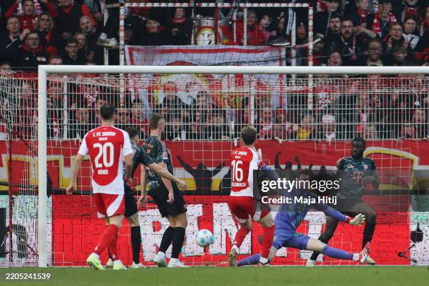 Jonas Urbig of Bayern Munich fails to make a save as Benedict Hollerbach of 1.FC Union Berlin scores his team's first goal during the Bundesliga...